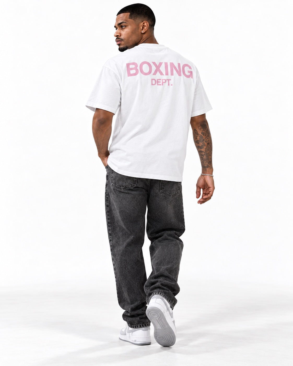 Modelo masculino de espalda con camiseta Boxing Dept. blanca y letras rosas